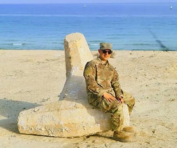 Antoni Pestka in U.S. Army uniform, seated on a beach